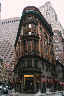 NEW YORK, ABD - 23 Şubat 2024: Çağdaş gökdelenlerin ortasında, hareketli bir şehir sokak ortamında güzel çarpıcı tarihi bir bina. Delmonicos Restoranı.