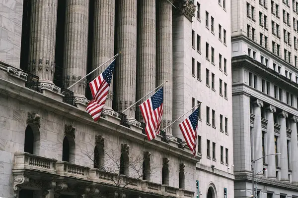 Finansal bir binadaki Amerikan bayraklarının varlığı herkes için ulusal gurur ve birliği güçlü bir şekilde sembolize ediyor. Wall Street 'te NYSE.