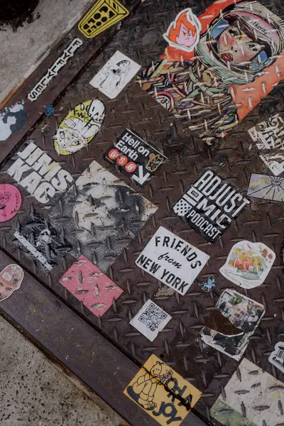 NEW YORK, ABD - 15 Nisan 2024: Bu canlı ve renkli çıkartmaların dokulu kentsel yüzeyi güzelce süsleyen yakın plan görüntüsü