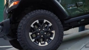 NEW YORK, ABD - 30 Mart 2024: Yeşil bir Jeep üzerindeki bir off-road lastiğinin görüntüsü, engebeli tasarım ve performans becerilerini vurguluyor