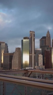 Çarpıcı güzellikte canlı bir şehir silueti, kasvetli bir gökyüzüne karşı parlak modern binalar. New York Manhattan, Brooklyn Köprüsü manzaralı.