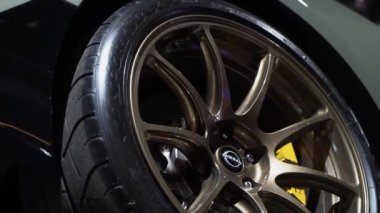 NEW YORK, ABD - 30 Mart 2024: Yüksek performanslı bir lastiğin çarpıcı bronz alaşımlı tekerleğinin yakın çekimi, zarif tasarımını güzel bir şekilde gösteriyor. Nissan GTR