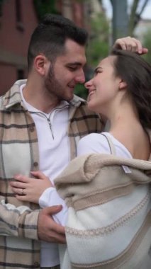 Dışarıda birbirine sırılsıklam aşık bir çift duruyor, samimi bir şekilde sarılıyor ve gülümsüyor, romantik bir anda yakınlaşıyorlar. Mutlulukları ve güçlü ilişkileri bu sevgi dolu kucaklaşmada aşikar.