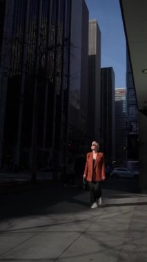 Şık ve şık bir birey, New York 'un çarpıcı şehir mimarisi ve dinamik gölgeleri arasında rahatça yürüyor.