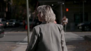 Şık bir kadın, sonbahar havası ve güzel şehir manzarasıyla dolu, hareketli şehirde geziniyor.