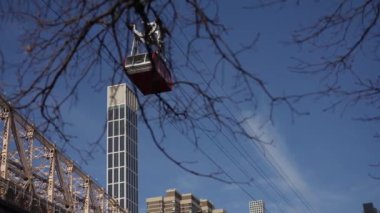 East River 'ın üzerinden geçen tramvay New York siluetinin muhteşem manzarasını sunuyor ve yakınlarda kiraz çiçekleri açıyor. New York 'taki Queensboro Köprüsü.