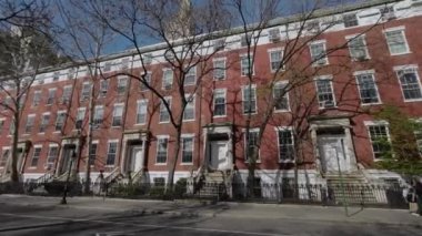 NEW YORK, ABD - 30 Mart 2024: Büyüleyici sıra evleri, 19. yüzyılın zarif mimari tarzlarını vurguluyor, huzurlu bir şehir manzarasına yerleşmiş