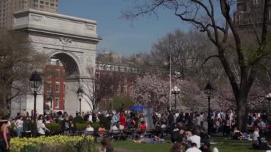 NEW YORK, ABD - 30 Mart 2024: Kalabalıklar güneşli bir bahar gününün tadını çıkarmak için Washington Square Park, NYC 'de toplandılar.