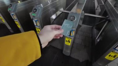 NEW YORK, ABD - 3 Mart 2024: Çalışan bir tren istasyonunda turnikelerden geçmek için geçiş kartını başarıyla kullanan bir kişi