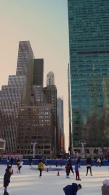 NEW YORK, ABD - 22 Şubat 2024: Canlı bir kış ortamında güzel gökdelenler arasında birlikte buz pateni yapmaktan mutluluk duyan insan grupları. Bryant Parkı