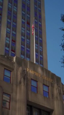 Bir bina, karmaşık tasarım ve mimarisini kentsel bir ortamda vurgulayan yüksek bir bayrak sergiliyor. New York 'taki Emprie State Binası