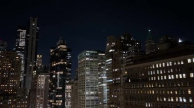 Geceleri hareketli bir şehrin nefes kesen silueti New York Manhattan 'daki parlak ışıklarla süslenmiş parlak binaları sergiliyor..