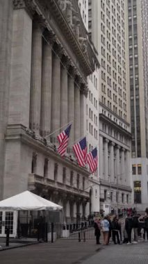 NEW YORK, ABD - 23 Şubat 2024 Wall Street 'in nefes kesici ve çarpıcı bir görüntüsü, simgesel mimarinin altını çiziyor ve Amerikan bayrağını sallıyor. New York Borsası Binası.