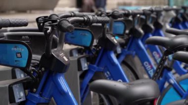 NEW YORK, ABD - 23 Şubat 2024: Mavi şehir bisikletleri düzenli bir şekilde dizilmiş, kentsel banliyö sakinleri için mükemmel bisiklet paylaşım seçenekleri sergiliyorlar. Citibike