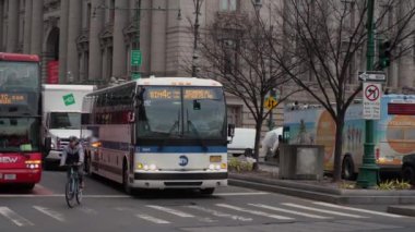 NEW YORK, ABD - 23 Şubat 2024: Trafikte ustalıkla yol alan çeşitli otobüs, kamyon ve bisikletçilerin sergilendiği hareketli ve yoğun bir şehir manzarası