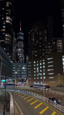 Gece boyunca aydınlatılmış binaların yer aldığı, modern mimarinin güzel bir şekilde sergilendiği canlı bir şehir.