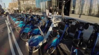 NEW YORK, ABD - 2 Şubat 2024: Kalabalık bir şehir ortamında parketmiş çok sayıda elektrikli scooter ve bisikleti gösteren canlı bir manzara. NYC 'de motosiklet paylaşımı.