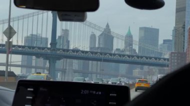 New York 'taki ikonik bir Manhattan köprüsünün altında eşsiz bir kentsel sürüş görüntüsü yakalamış bir arabanın içinden nefes kesici bir manzara.