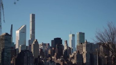 Gökdelenlerin açık mavi gökyüzüne karşı inşa edildiği canlı bir şehrin gökdelen manzarasını deneyin. Manhattan New York.