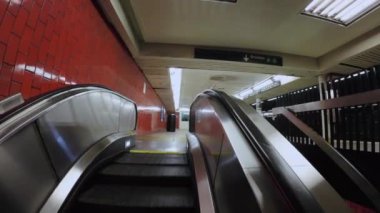 Canlı ve hareketli bir metro istasyonunda şehir mimarisini vurgulayan bir yürüyen merdivenin büyüleyici görüntüsü. New York