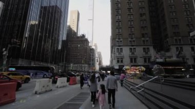 NEW YORK, ABD - 30 Mart 2024: Hareketli bir şehir hayatı, yüksek gökdelenlerle çevrili hareketli bir caddede canlı bir şekilde yakalandı