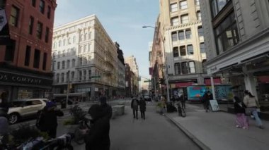 NEW YORK, ABD - 3 Mart 2024: İnsanlarla dolu canlı bir şehir caddesi, hem tarihi binaları hem de modern yaşamı uyum içinde sergiliyor