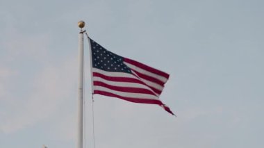Açık ve güneşli bir günde rüzgarda dalgalanan Amerikan bayrağının güzel bir tasviri.