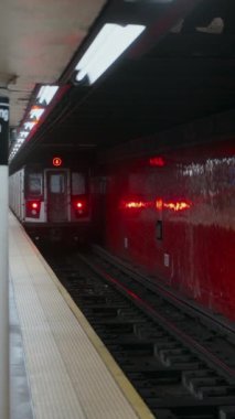 Metalik yüzeyini ve istasyona gelen pencereyi gösteren metro vagonunun detaylı ve yakın görüntüsü..
