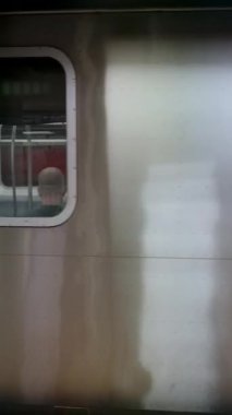 NEW YORK, ABD - 12 Kasım 2024: Bu, metalik yüzeyini ve istasyona ulaşan pencereyi gösteren bir metro vagonunun ayrıntılı ve yakın görüntüsü.