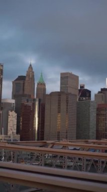 Çarpıcı güzellikte canlı bir şehir silueti, kasvetli bir gökyüzüne karşı parlak modern binalar. New York Manhattan, Brooklyn Köprüsü manzaralı.