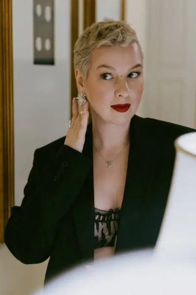 Şık siyah elbiseli ve iç çamaşırlı zarif bir kadın sonsuz zarafet ve modern kadınlığı bir lambayla sergiliyor, kendinden emin ve cesur tarzıyla sofistike, güzel ve çekici.