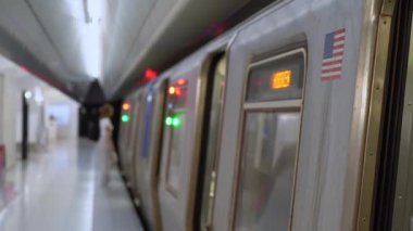 Sakin bir metro istasyonu, hareketli kentsel yaşamı ön plana çıkaran, bekleyen bir tren ve asgari bir kalabalığı gösteriyor. Metro İstasyonu Yoğun Bir Şehirde Eşsiz Bir Modern Seyahat Deneyimi Sunuyor