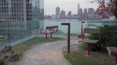 Huzurlu ve sakin bir şehir parkı geniş bir oturma yeri ve yemyeşil, göz kamaştırıcı bir şehir arkaplanı var.