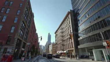 NEW YORK, ABD - 8 Aralık 2024: Parlak mavi gökyüzü altında tarihi ve modern mimari tarzların bir karışımını sergileyen hareketli bir sokak sahnesi