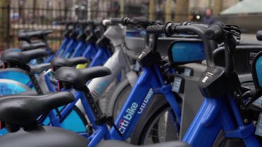 NEW YORK, ABD - 23 Şubat 2024: Mavi şehir bisikletleri düzenli bir şekilde dizilmiş, kentsel banliyö sakinleri için mükemmel bisiklet paylaşım seçenekleri sergiliyorlar. Citibike