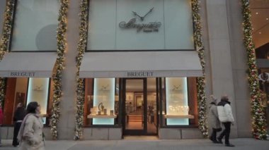 NEW YORK, ABD - 29 Kasım 2024: Şenlikli ve renkli süslemelerle süslenmiş şık bir mücevher butiği, hareketli bir caddede yer alıyor