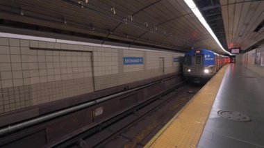 JERSEY CITY, ABD - 24 Kasım 2024: Bir metro treni insanların toplandığı modern, hareketli bir yeraltı istasyonunda platforma yaklaşıyor