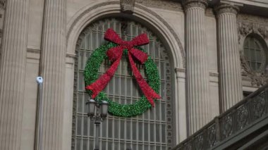Güzel süslenmiş kırmızı kurdeleli bir çelenk Grand Central İstasyonu 'ndaki şenlik ruhunu kutluyor..