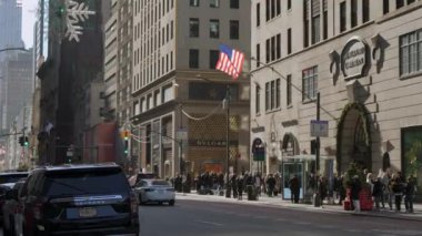 NEW YORK, ABD - 8 ARALIK 2024: Değişik yaya trafiği ve hareketli bir şehir manzarasında şenlikli dekorasyonların yer aldığı canlı ve canlı bir sokak sahnesi