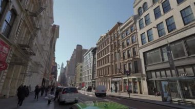 NEW YORK, ABD - 8 Aralık 2024: Canlı bir şehir sokak sahnesinde açık mavi gökyüzü altında tarihi ve modern binaların bir karışımı yer alıyor