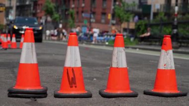 Parlak turuncu trafik konileri işlek bir cadde boyunca dizilmiş. Bu da bir inşaat ya da yol çalışması alanı olduğunu gösteriyor.
