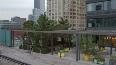 Sarı mobilyaların ve yeşilliklerin bulunduğu canlı bir açık hava oturma alanı. Toplantılar için mükemmel..