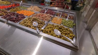 Canlı ve renkli bir dizi taze zeytin ve yerel bir markette güzelce sergilenen lezzetli meyveler.