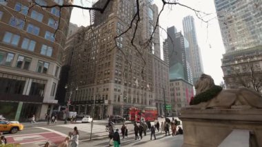 NEW YORK, ABD - 30 Kasım 2024: Yayalar ve parlak sarı taksilerle dolu canlı bir cadde, şehir hayatının ve mimarisinin özünü gözler önüne seriyor