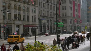 NEW YORK, ABD - 30 Kasım 2024: Yayalar ve parlak sarı taksilerle dolu canlı bir cadde, şehir hayatının ve mimarisinin özünü gözler önüne seriyor
