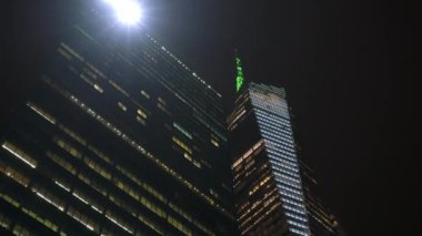 Çarpıcı bir gece manzarası New York 'ta canlı şehir ışıkları ve yemyeşil ağaçların arasında muhteşem bir gökdelen barındırıyor.