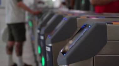 Yoğun bir ulaşım merkezinde otomatikleştirilmiş turnikeleri kullanan yolcular modern seyahat teknolojilerini sergiliyorlar. Metro ya da tren istasyonu.