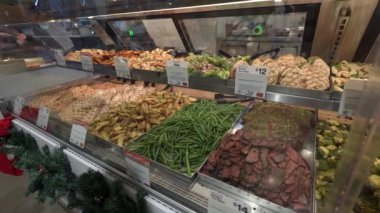 Modern bir markette müşteriler için canlı bir taze sebze ve et seçimi sergilenmektedir..