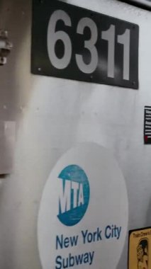 NEW YORK, ABD - 12 Kasım 2024: Bu, metalik yüzeyini ve istasyona ulaşan pencereyi gösteren bir metro vagonunun ayrıntılı ve yakın görüntüsü.