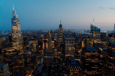 Gün batımında New York 'un göz kamaştırıcı gökdelenlerini deneyin. Canlı şehir ışıklarıyla aydınlatılmış ikonik gökdelenler. Muhteşem ve nefes kesici Günbatımı Görünümü Iconic Manhattan Skyline üzerinde